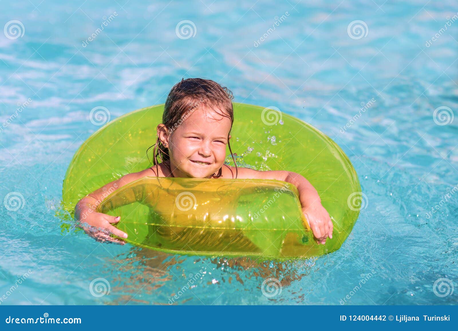 Funny Little Girl Swims in a Pool in at Green Life Preserver Stock ...