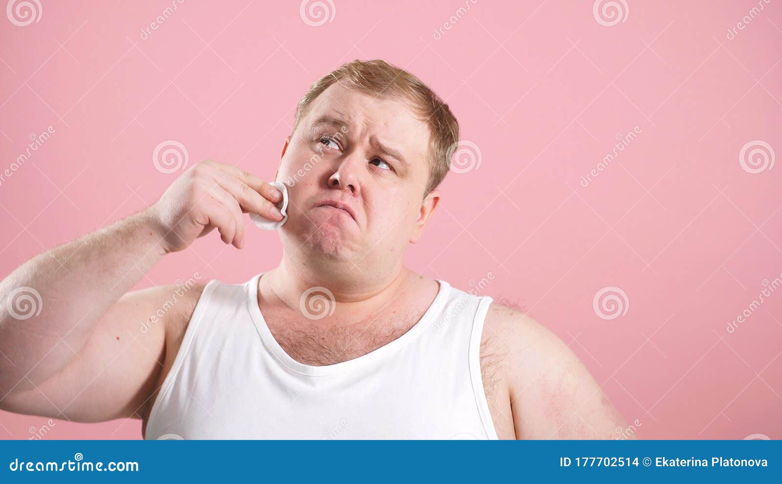 Funny Fat Man In A Tshirt Wipes His Face With A Cotton Pad On An