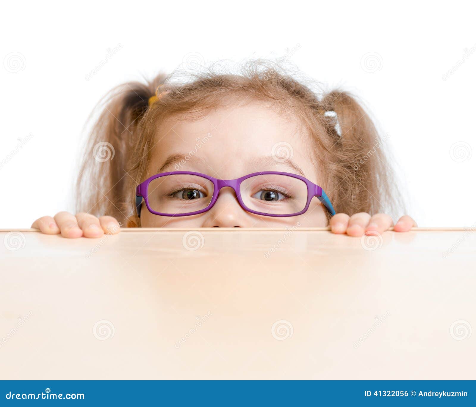 funny girl in eyeglasses hiding behind table