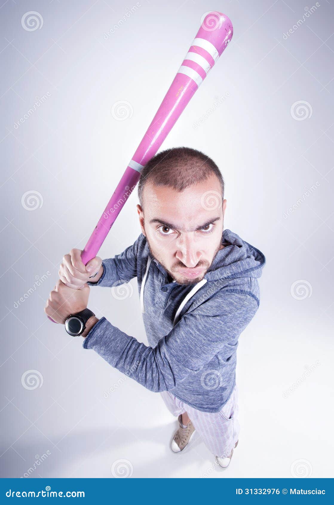 funny hooligan with a pink baseball bat looking angry in the studio