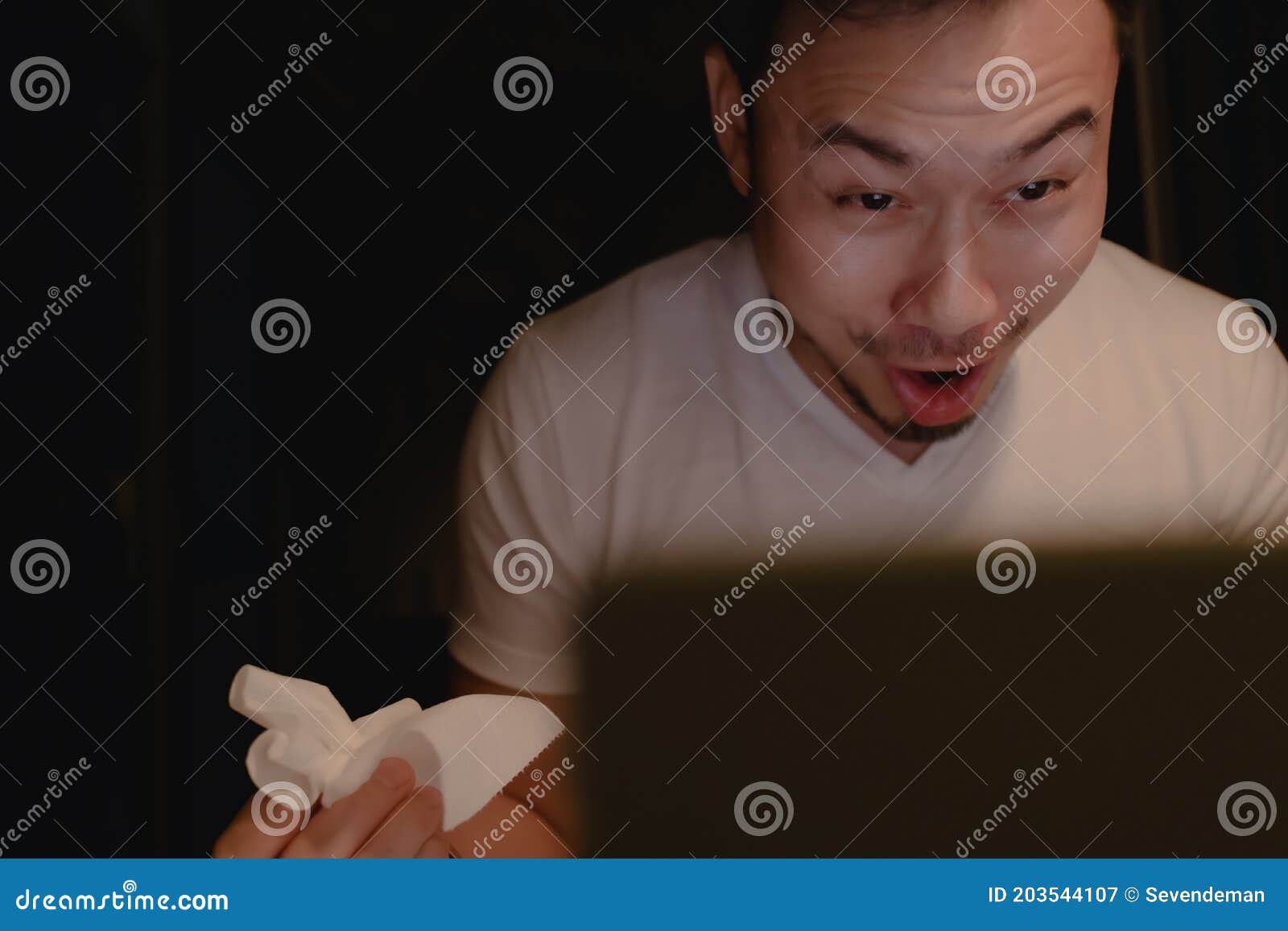 funny horny face of man watching porn at night.
