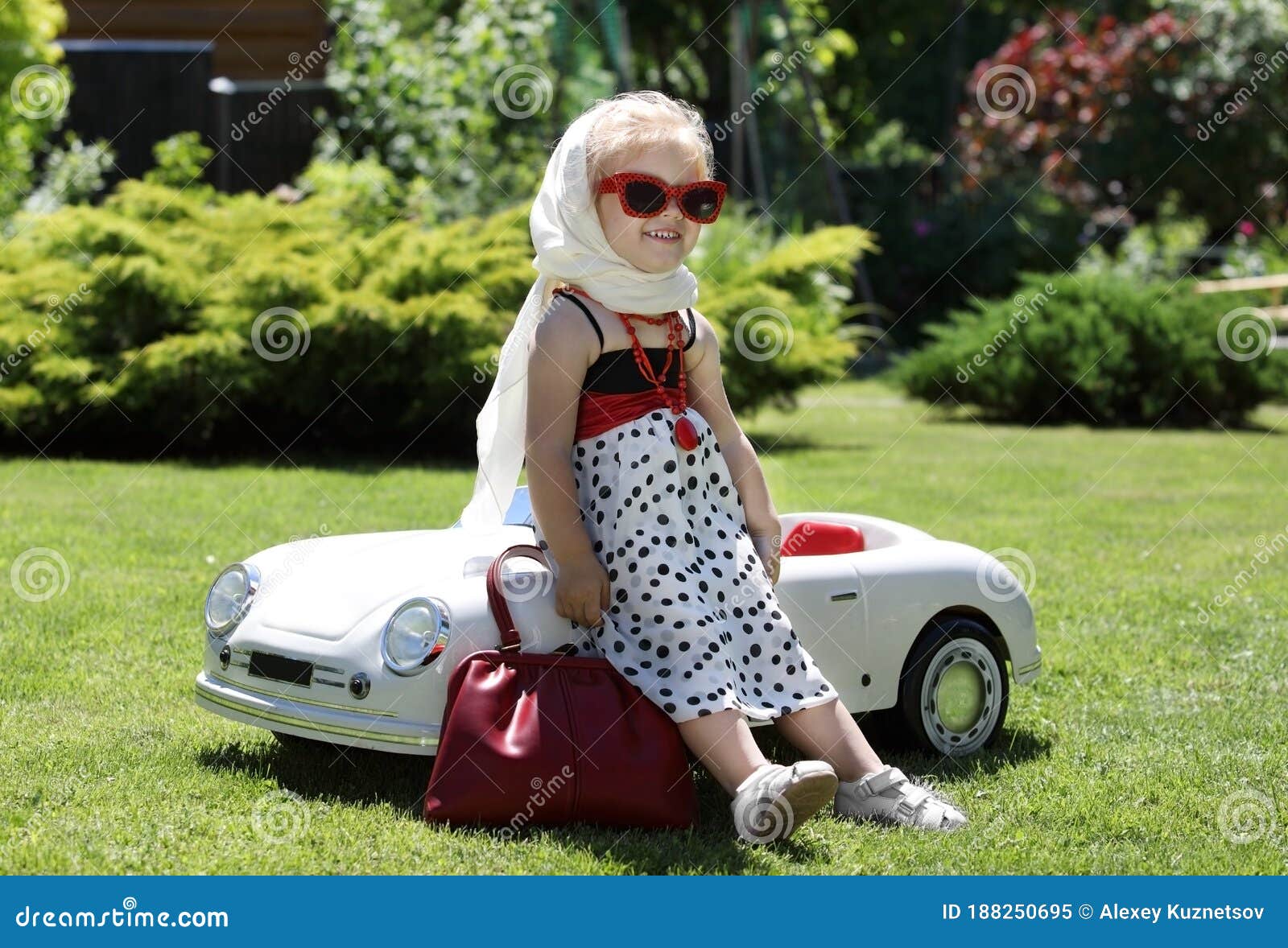 Funny Little Blonde Girl Leaned Against A Toy Car Stock Image