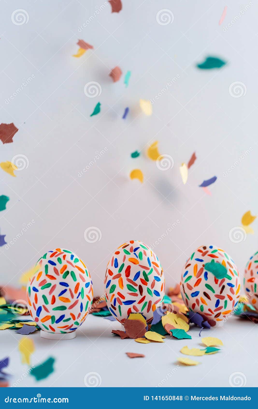 funny multicolored easter eggs hand painted and splash of colorful papers in movement