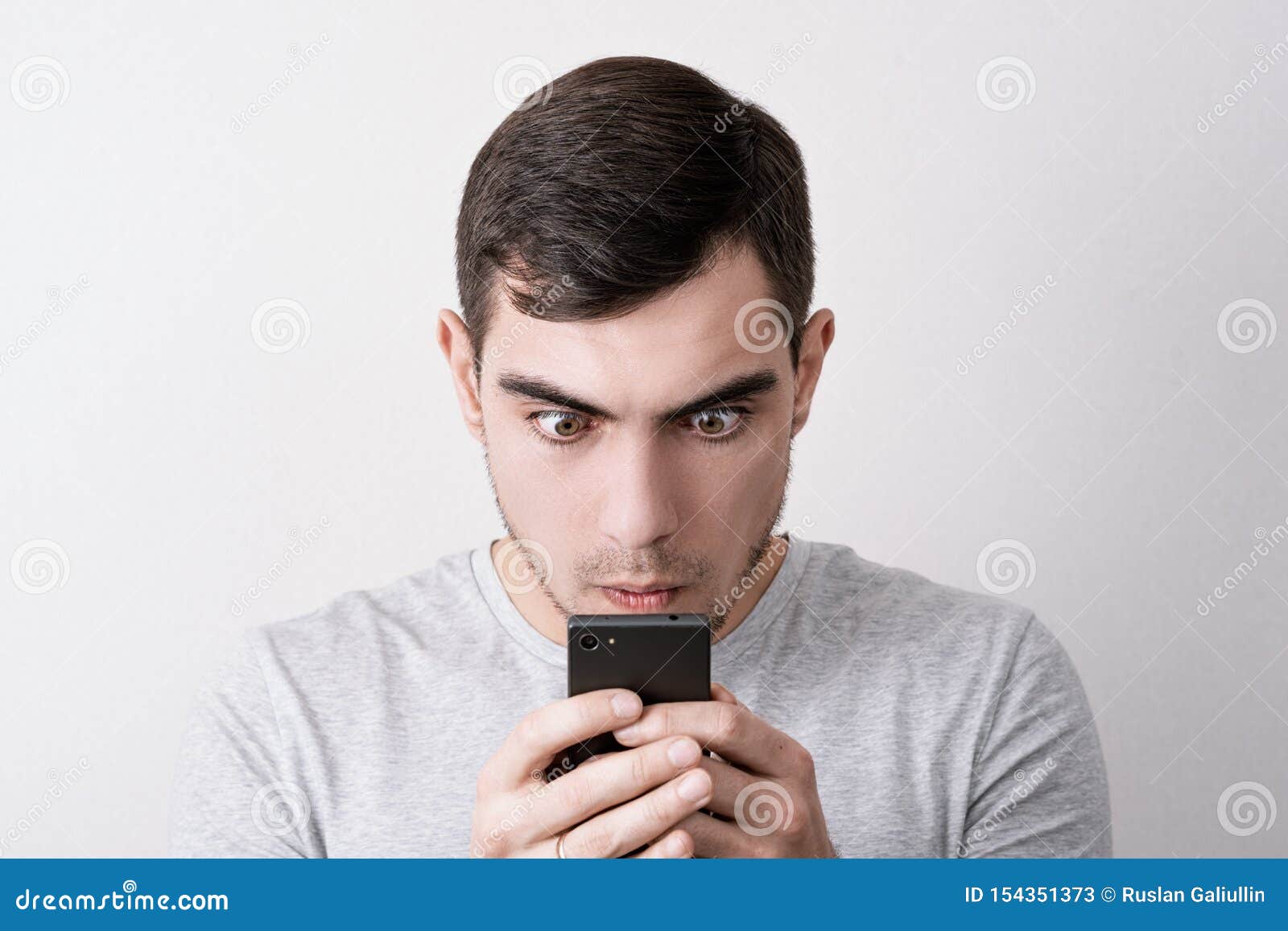 Funny Portrait of Man with a Smartphone in His Hands Looking at the ...