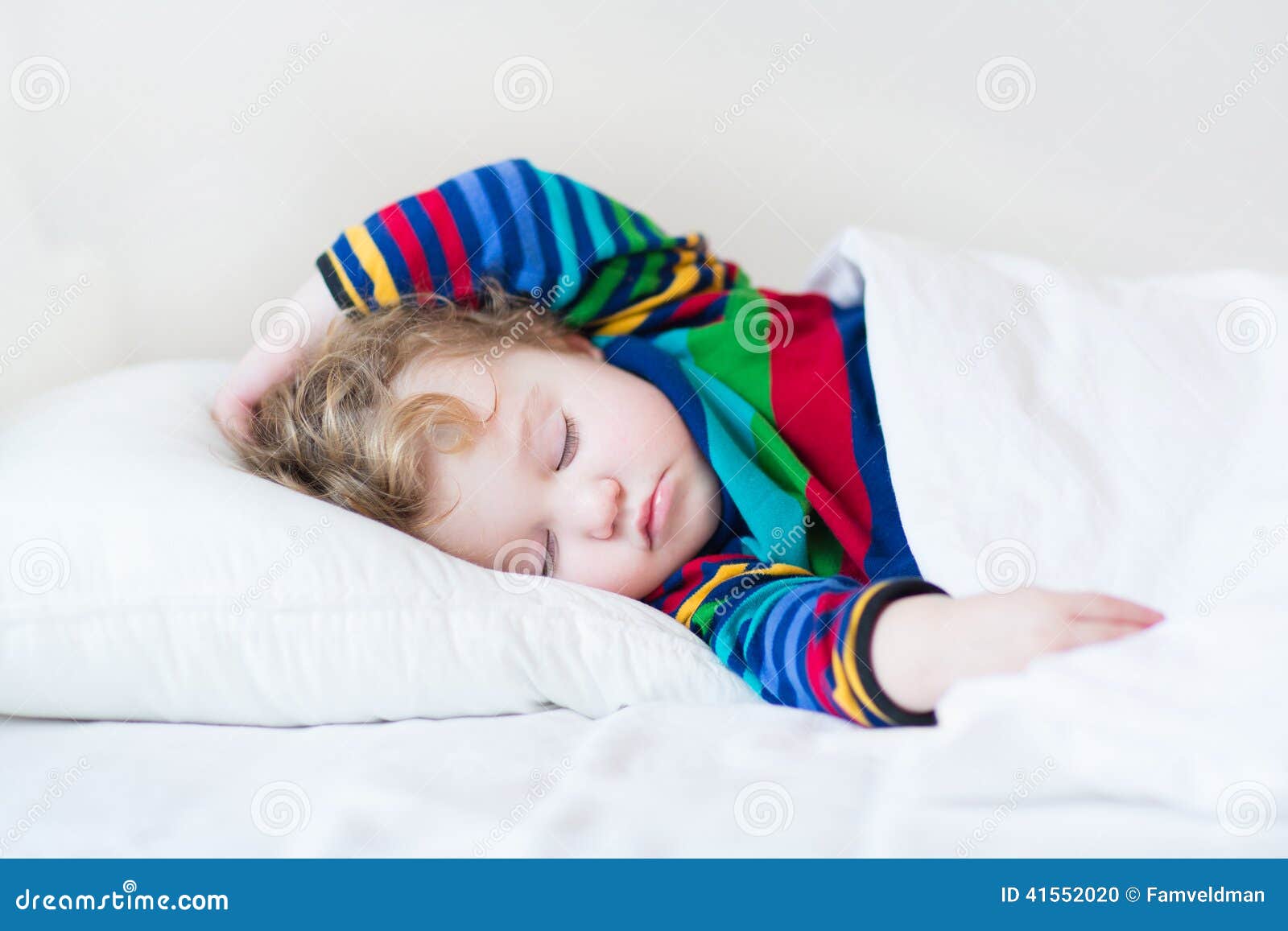 funny sleeping toddler girl in a white bed