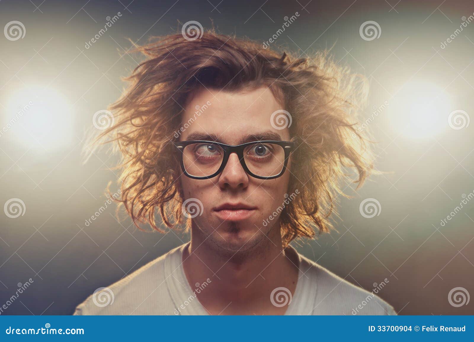 funny squinting man with tousled brown hair in studio