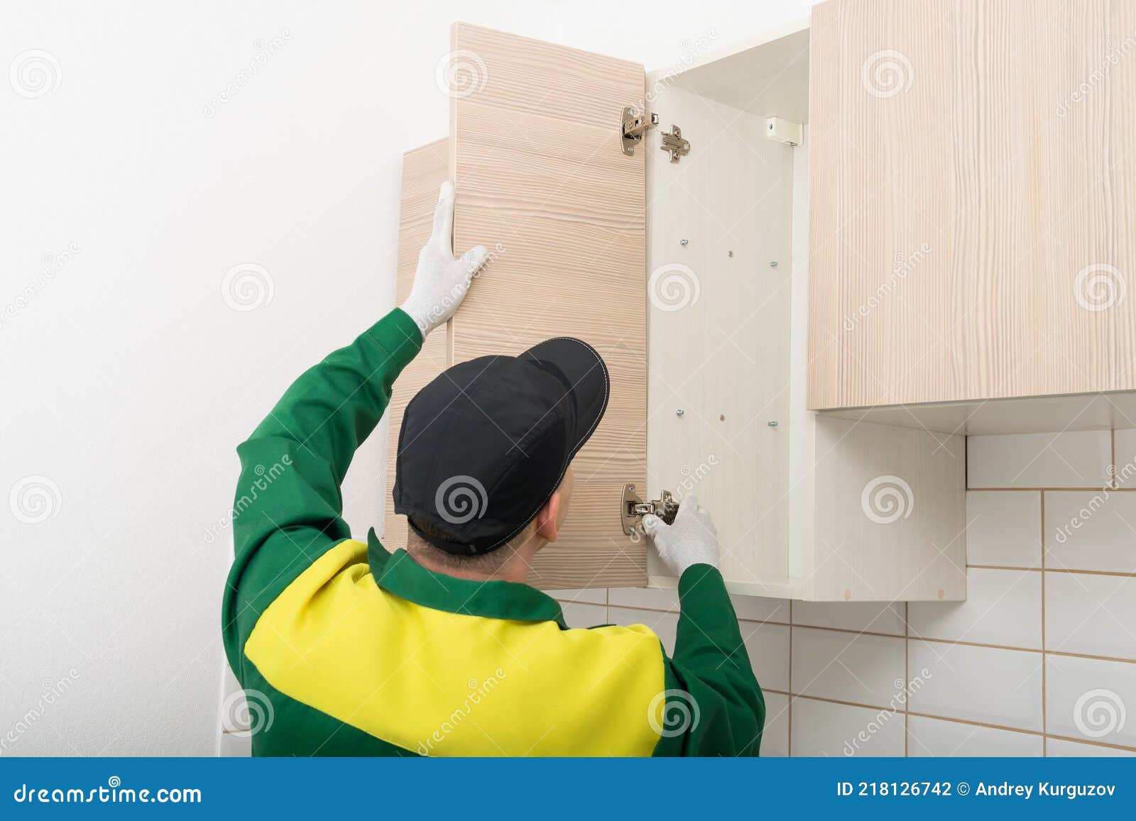 the furniture assembly specialist hangs the fronts on the top cabinet of the kitchen unit