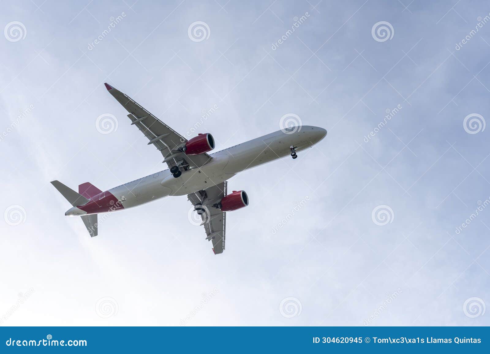 fuselage of a passenger plane at low altitude near the runway with the landing gear deployed