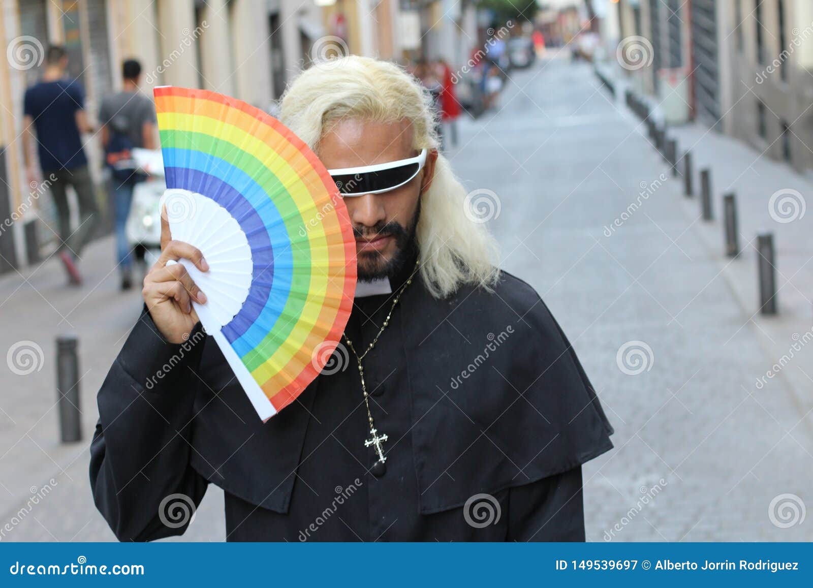 Futuristic Looking Priest Holding a Rainbow Fan Stock Image