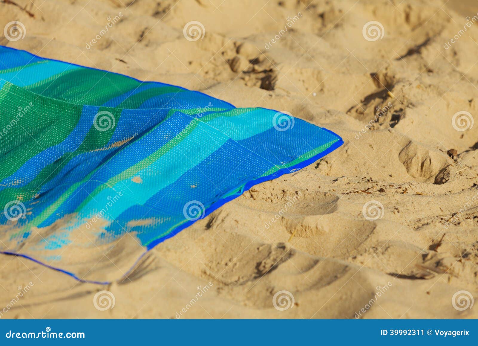 Férias de verão. Esteira vazia do verde azul na praia. Férias de verão. Close up da cobertura listrada vazia de toalha da esteira do verde azul na praia. Sunbath bronzeado relaxa na costa de mar. verão.