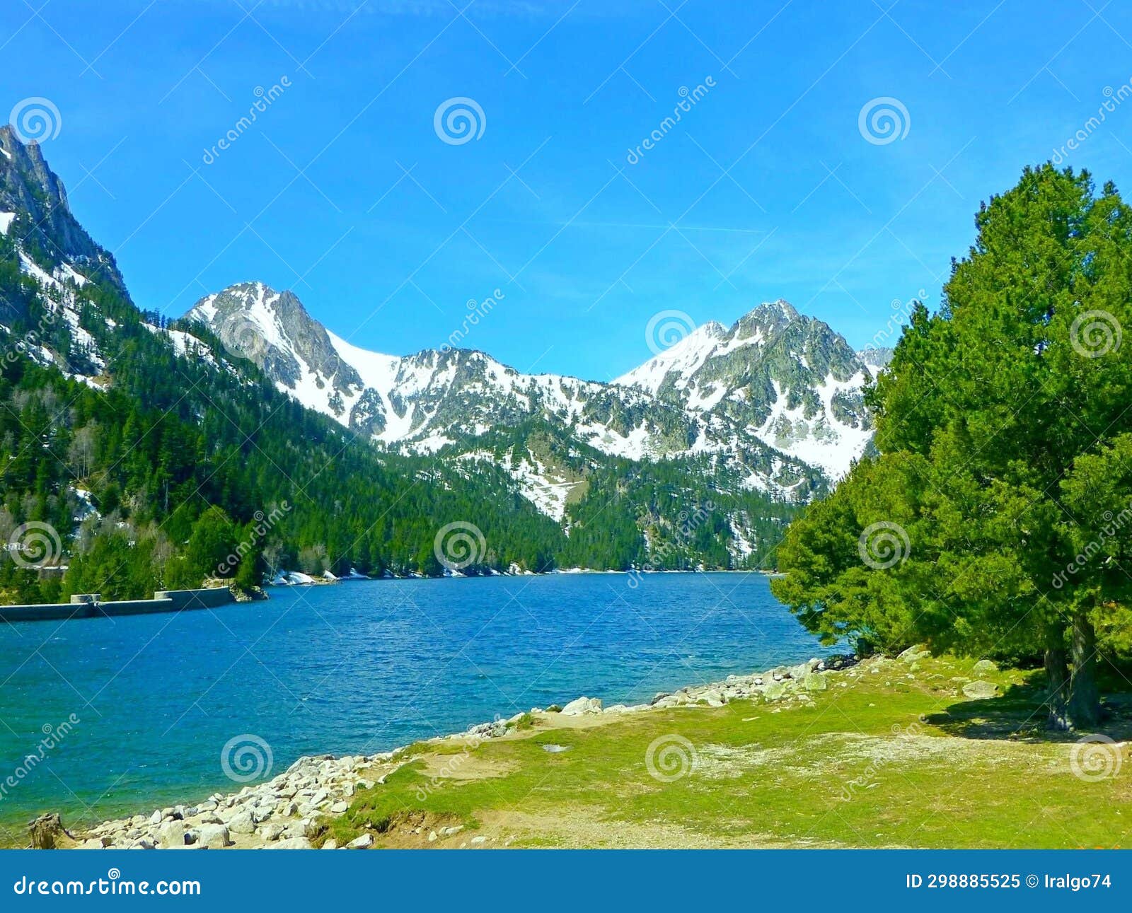 landscape with an alpine lake surrounded by snow-capped peaks of the pyrenees mountains in spain