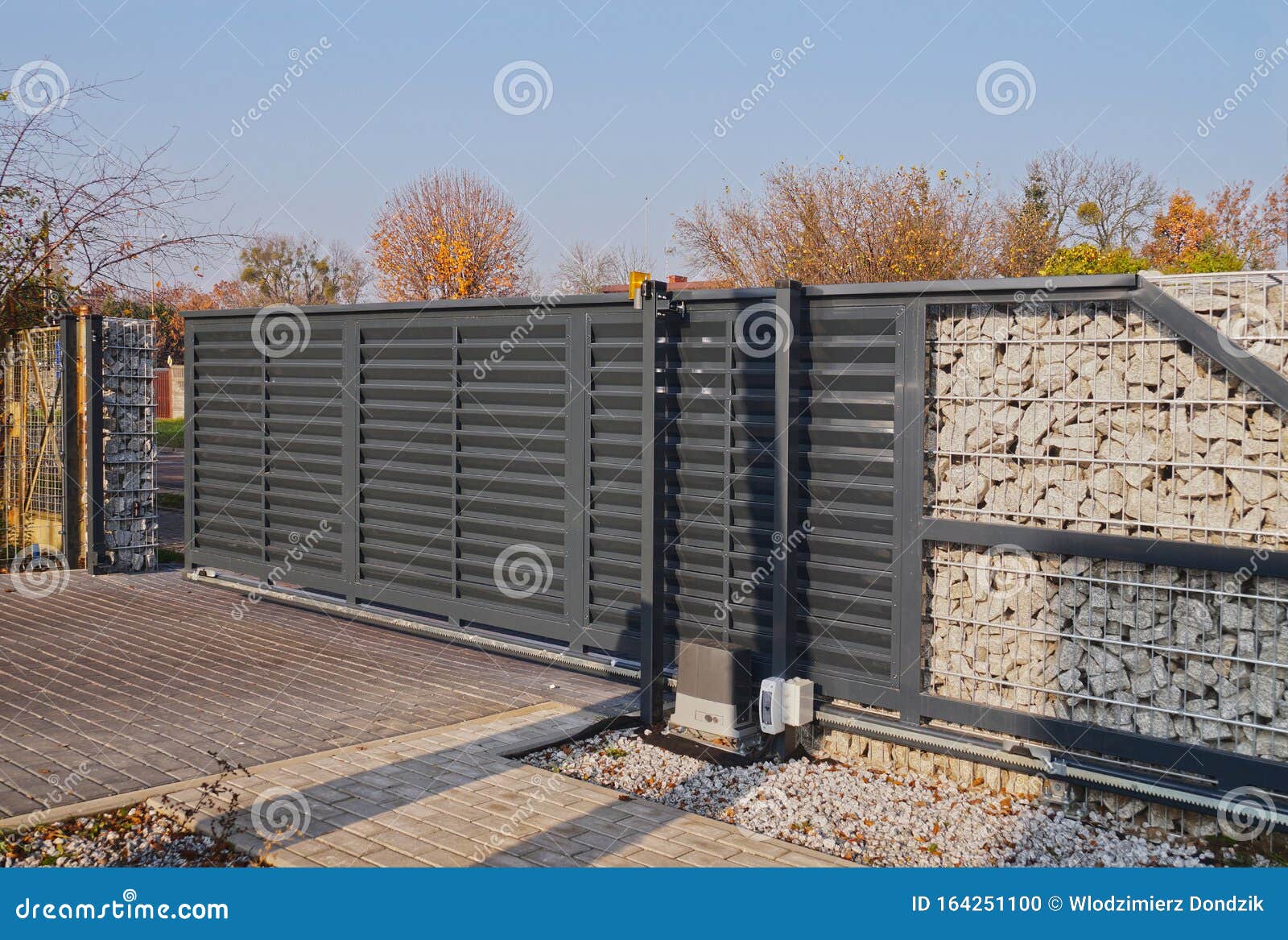 gabion. automatic entrance gate used in combination with a wall made of gabion