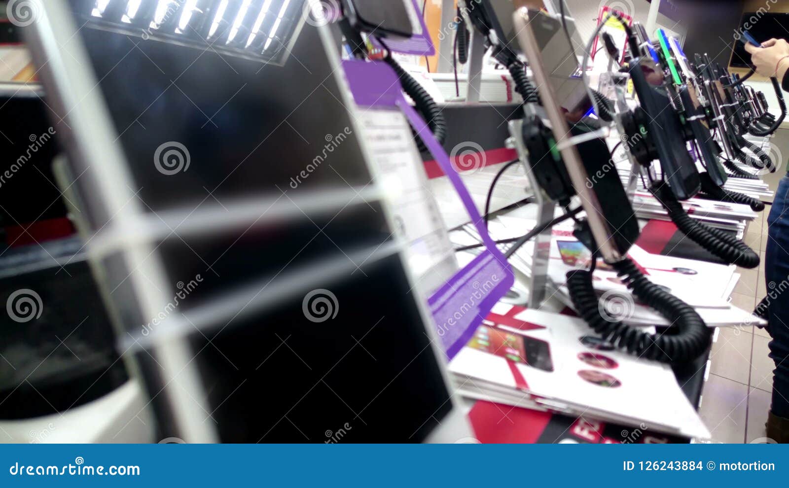 gadget showroom at electronics store, buyers testing and choosing smartphones