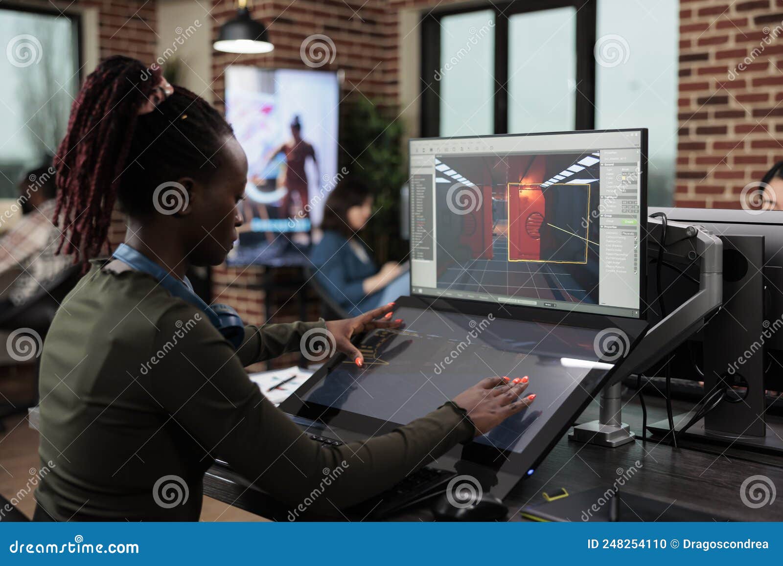 Game Designer Sitting in Office Workspace while Working on Environment