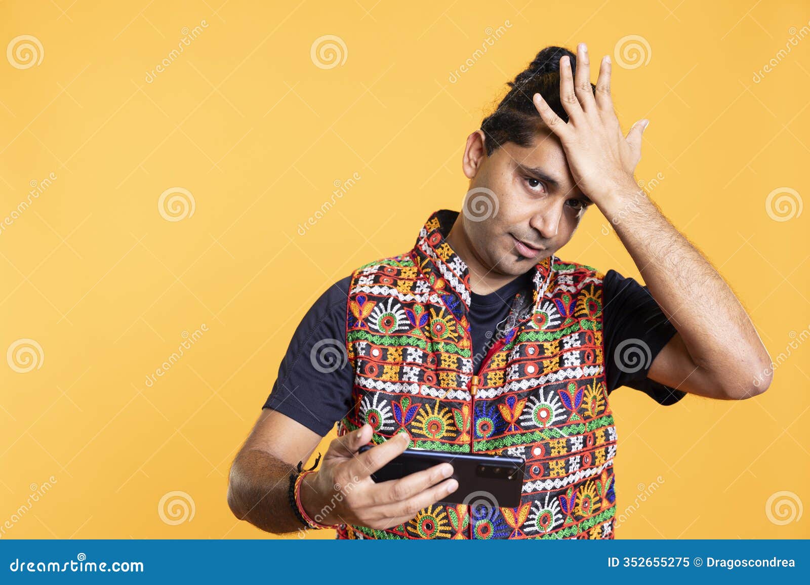 gamer annoyed after losing videogame on cellphone, doing facepalm hand gesture