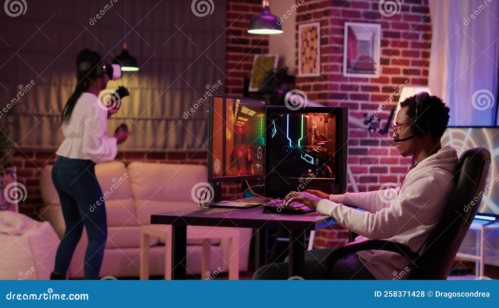 Gamer Playing Multiplayer First Person Shooter while Gaming Girl is Fighting in Virtual Reality Boxing Stock Photo
