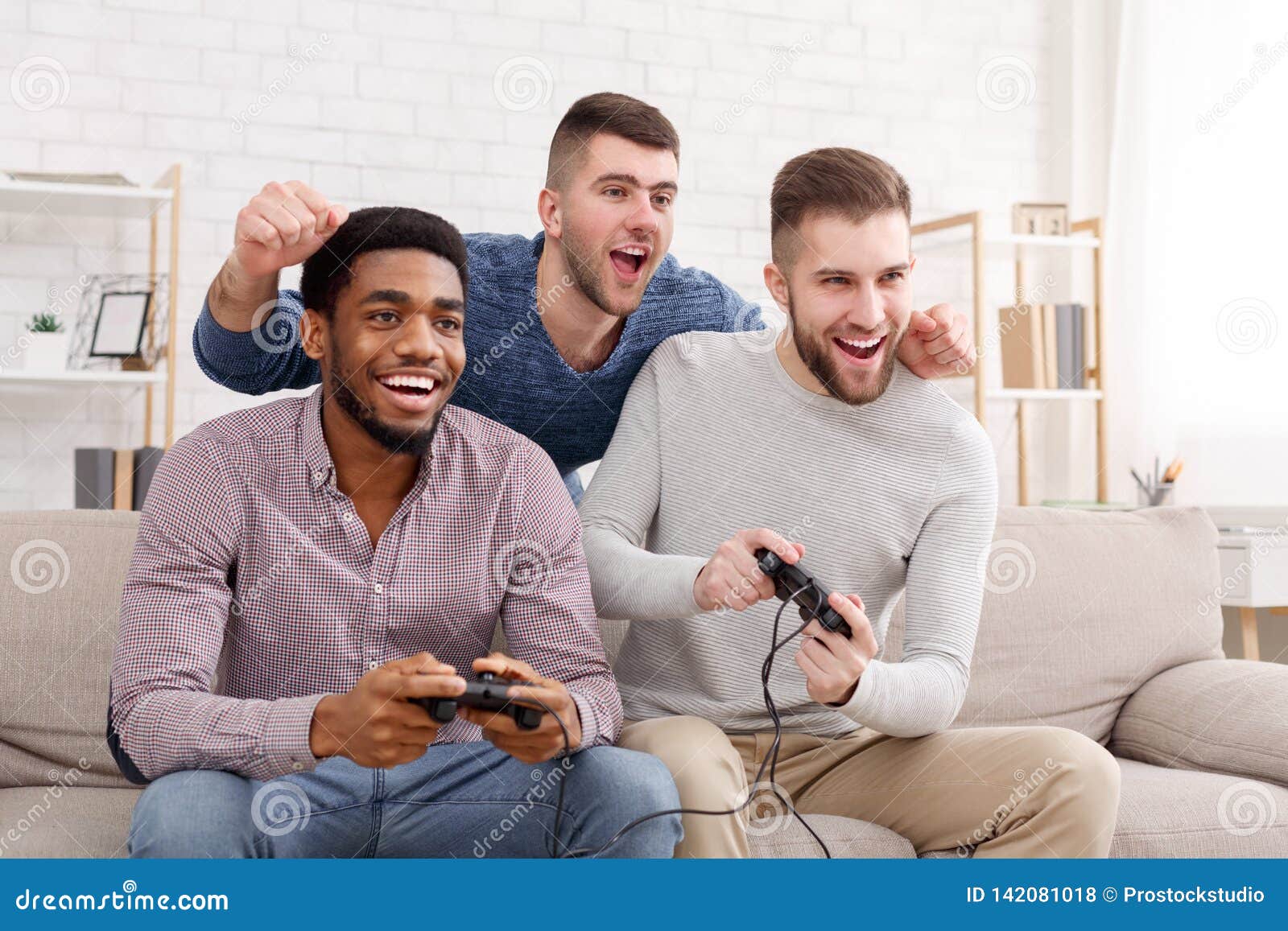 Amigos gamers animados jogando videogame em casa rindo enquanto