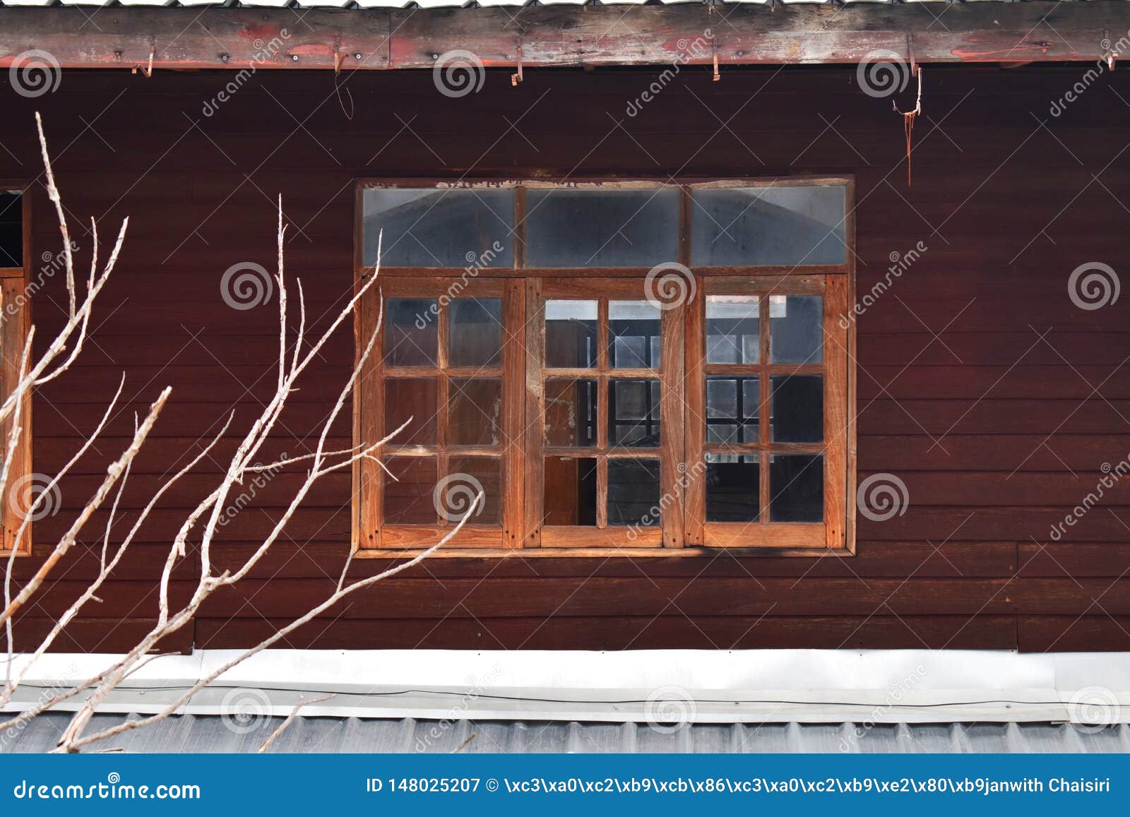 Gamla trähusfönster i Thailand. Gammal trävägg med röda/bruna träplankor för förfalla och gamla vita fönster