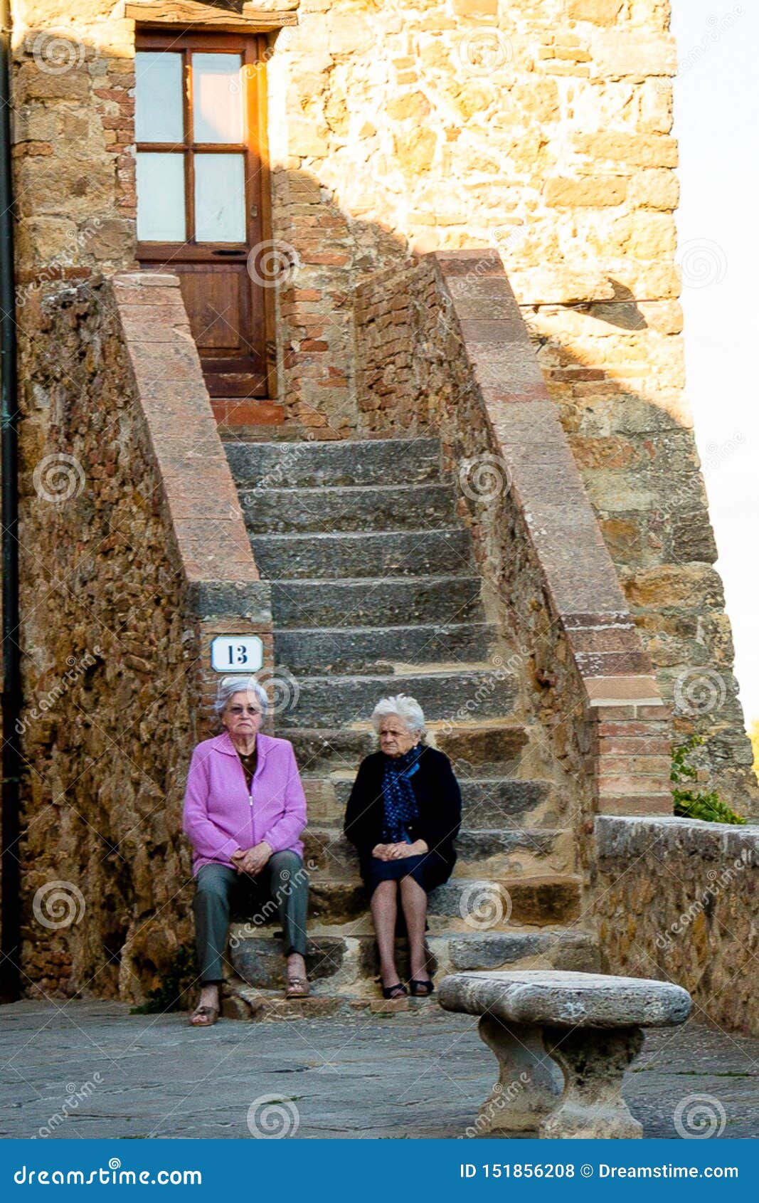 Gamla wimen som sitter trappan Italien. Italienska grandmathers som stting nära hus i Italien i vår Bra se Diskutera grannar som memorerar förgångna tider