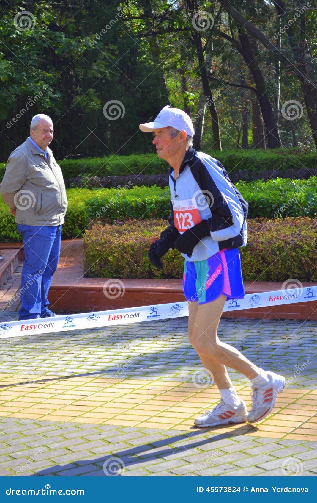 Gammal långdistans- löpare. Gamala mannen som bara kör på, parkerar gränder under 31st Sofia Marathon, den förtjusande beundransvärda handlingen, anmärkningsvärd fasthet