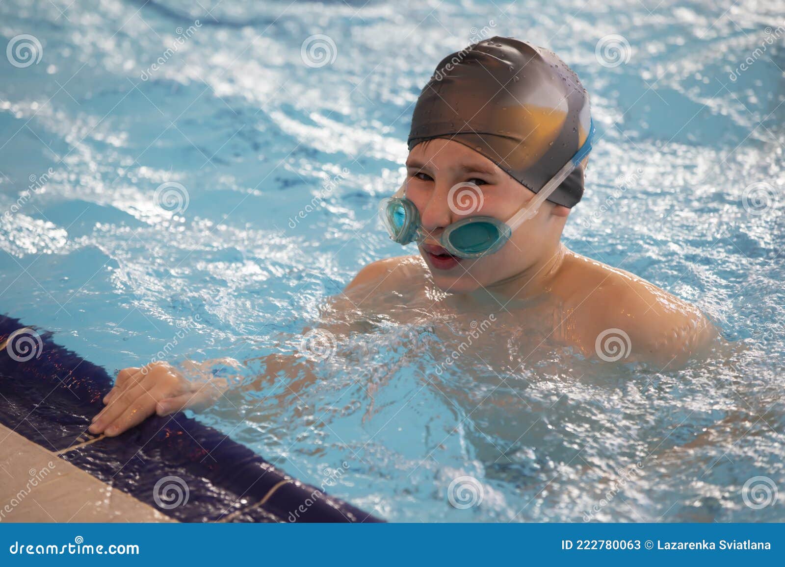 Garçon Dans Un Bonnet De Bain Et Des Lunettes De Natation Dans La Piscine.  L'enfant Est Engagé Dans La Section De Natation.