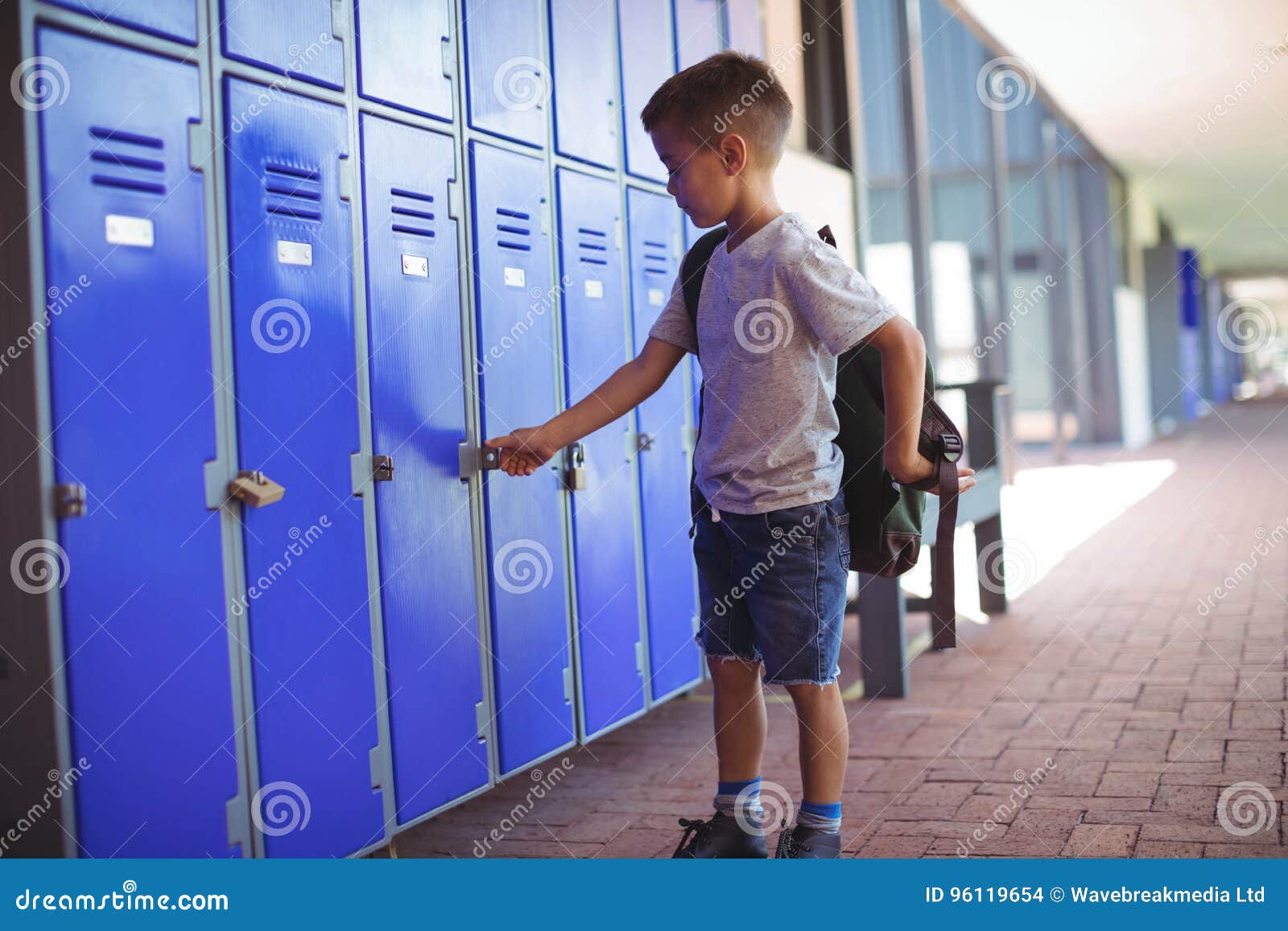 Garçon Fermant à Clef Le Casier Tout En Portant Le Sac Photo stock - Image  du enfant, brun: 96119654