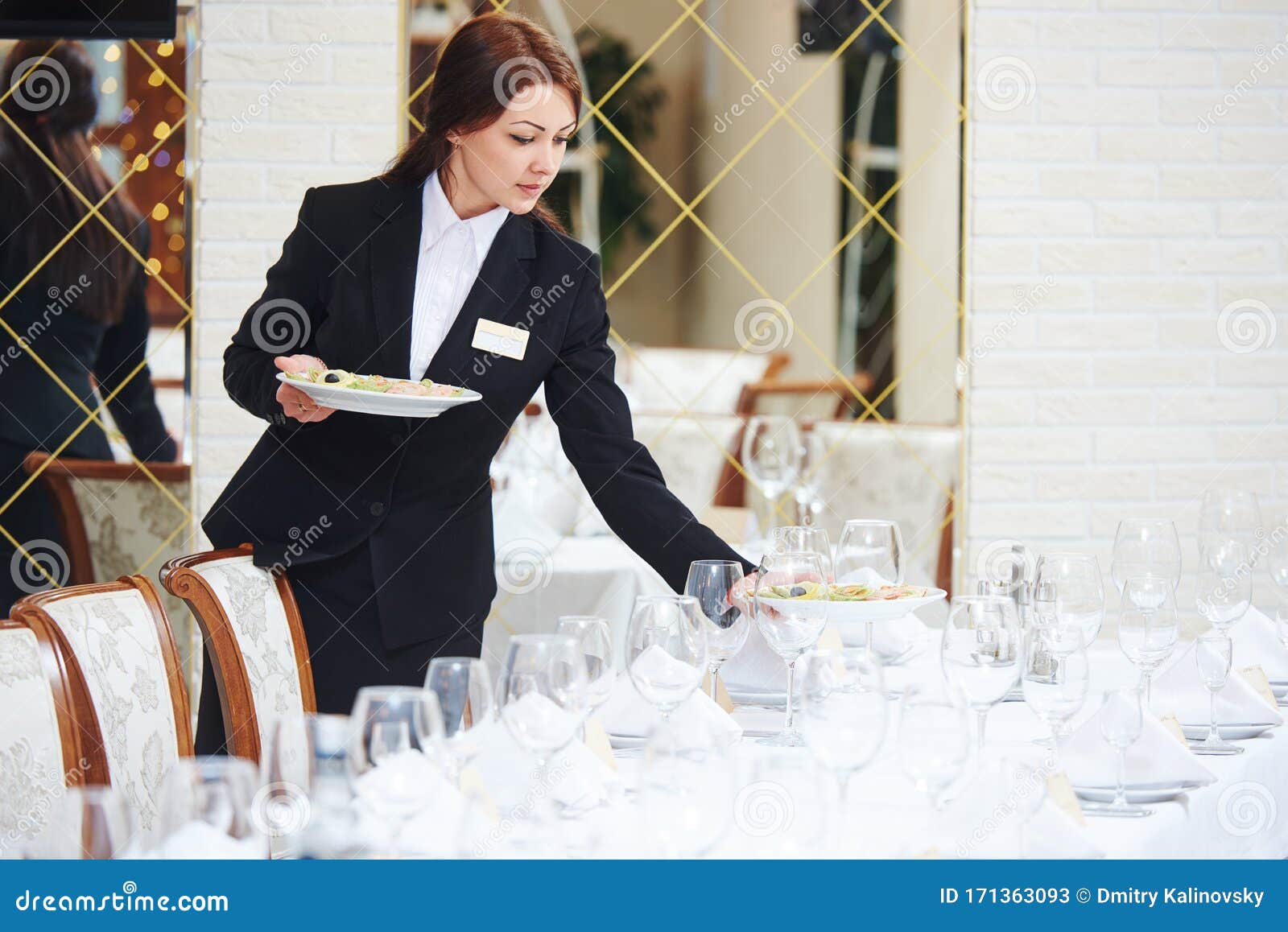 Garçonete De Restaurante Servindo Mesa Com Comida Imagem de Stock