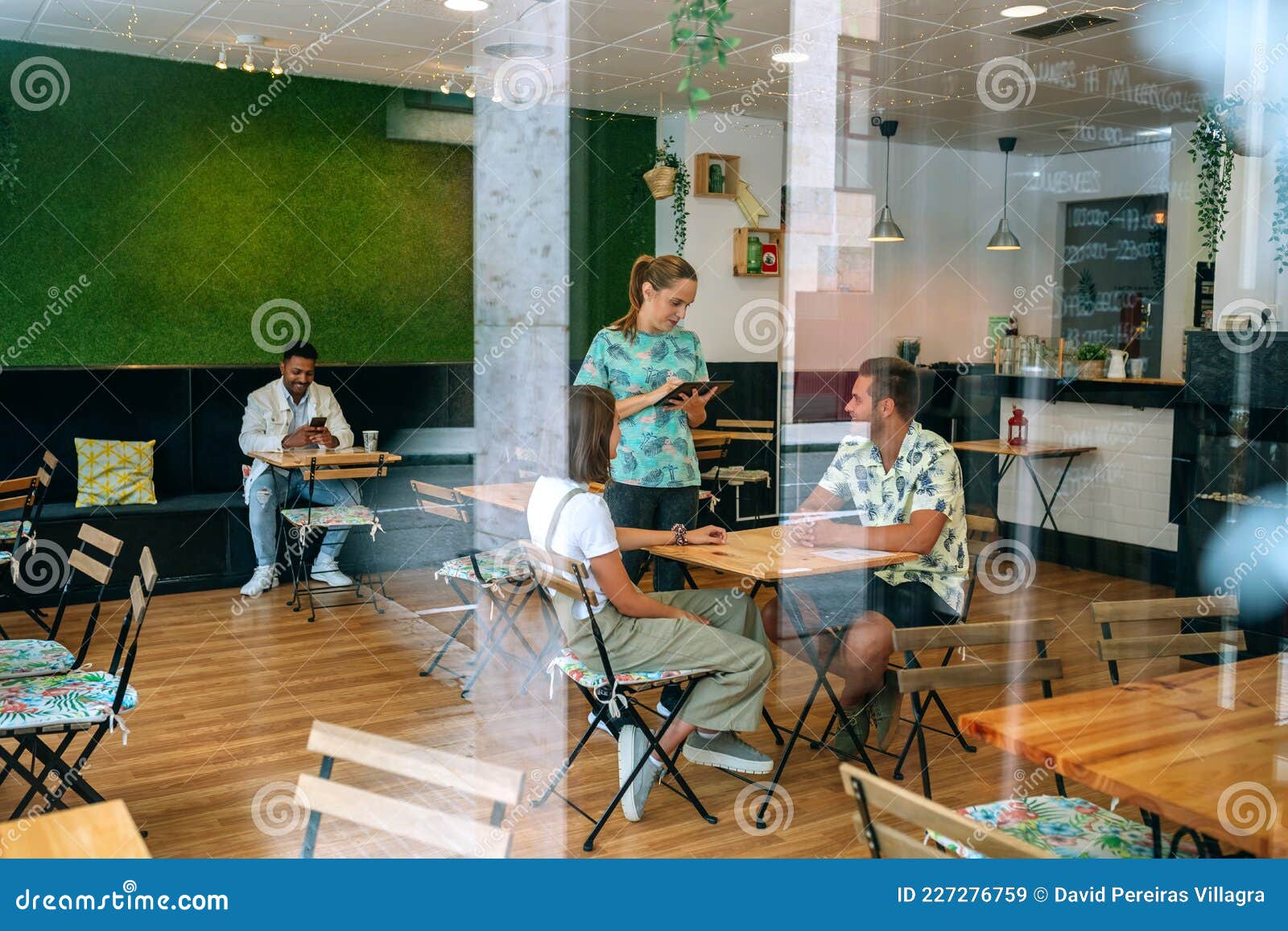 Garçonete recebendo ordens de pessoas no restaurante