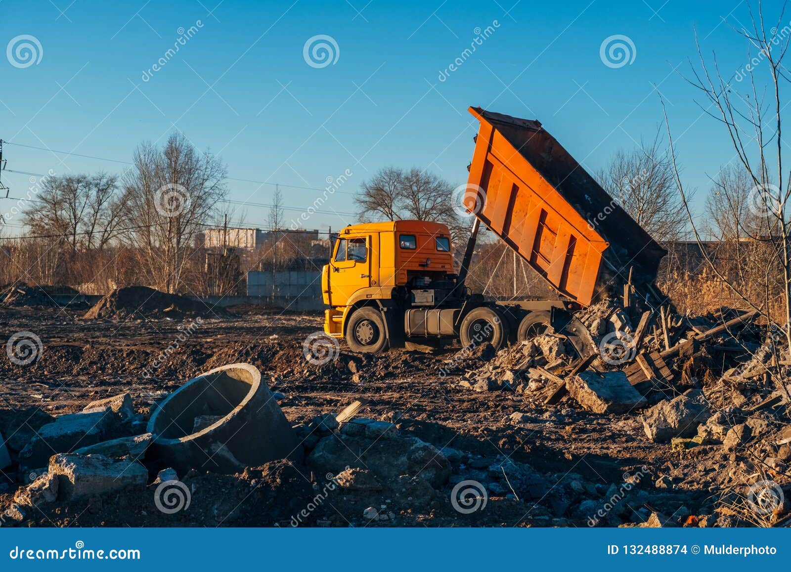 Garbage Dump Truck Unloading Construction Debris into Landfill Stock