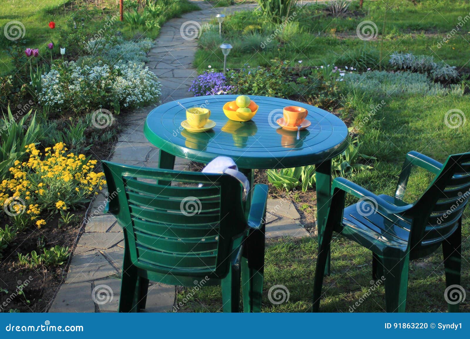 Garden Furniture Among Flowers Near Garden Path Of