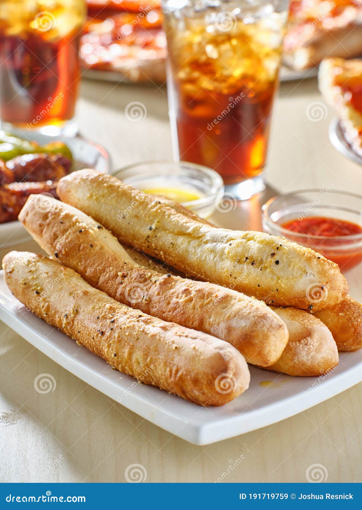 Garlic Butter Breadsticks With Soda And Pizza In Background Stock Image