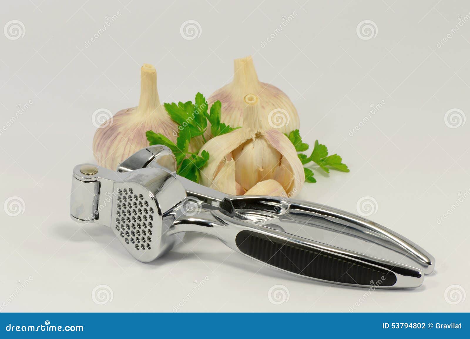 Garlic and a garlic press on a white background.