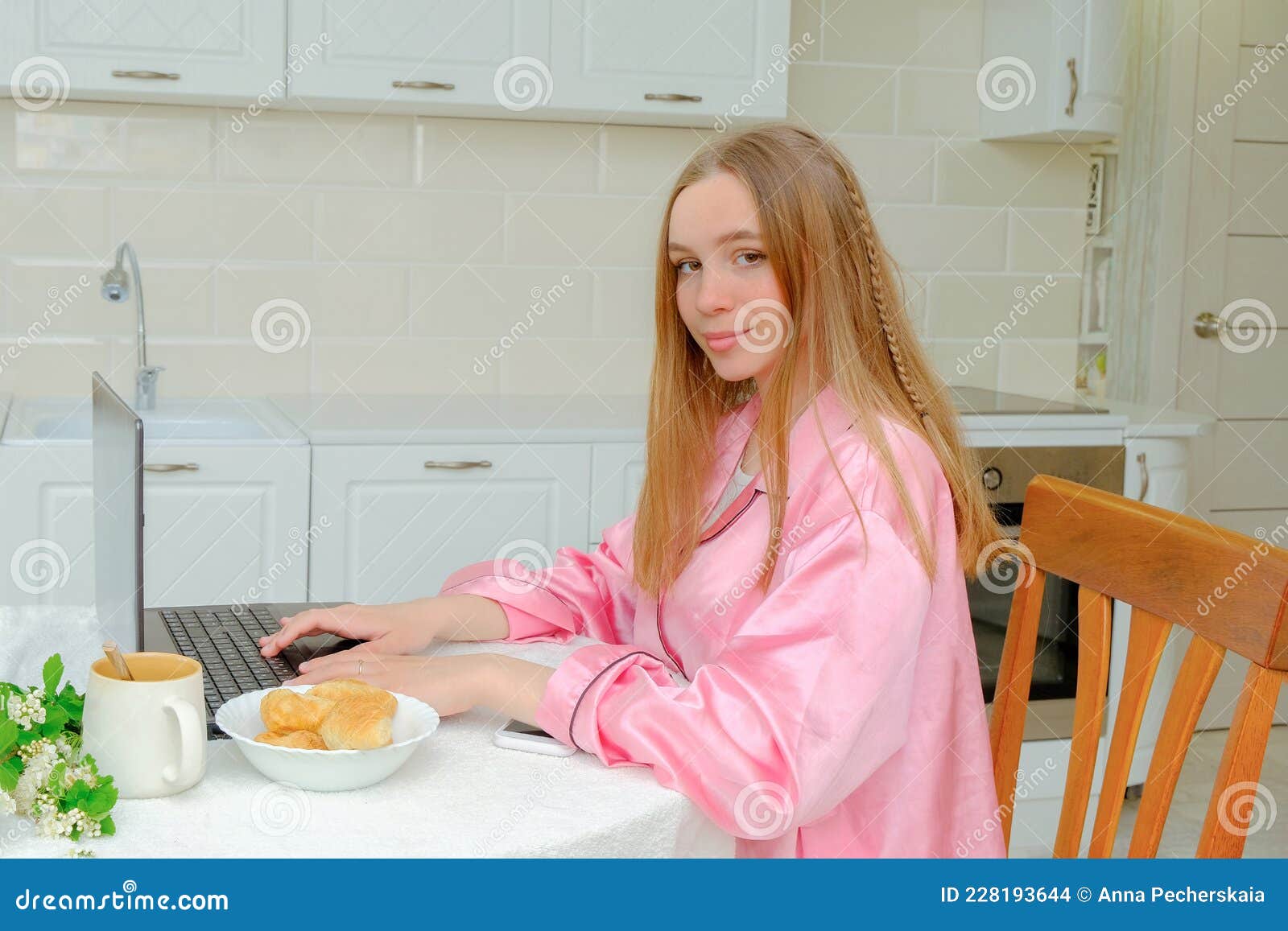 Garota De Pijama Rosa Senta-se Na Cozinha Com Um Laptop Na Mesa E Olha Dentro Da Moldura. Bom Dia. Uma Caneca Com Uma Bebida Foto de Stock - Imagem de casa, tecnologia: Garota De Pijama Rosa Senta-se Na Cozinha Com Um Laptop Na Mesa E Olha Dentro Da Moldura. Bom Dia. Uma Caneca Com Uma Bebida Foto de Stock - Imagem de casa, tecnologia: