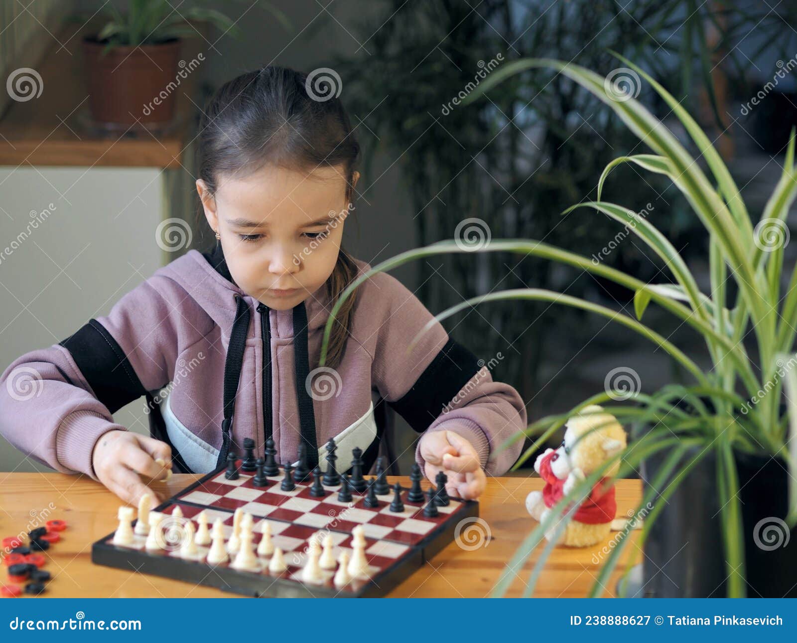 Uma Menina Aprende Como Jogar O Jogo De Xadrez Imagem de Stock