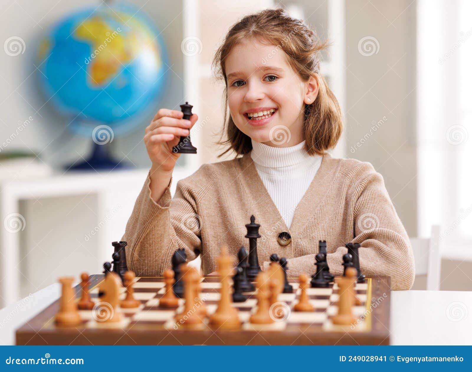 Garota Feliz Jogando Xadrez Na Sala De Aula Clara Imagem de Stock