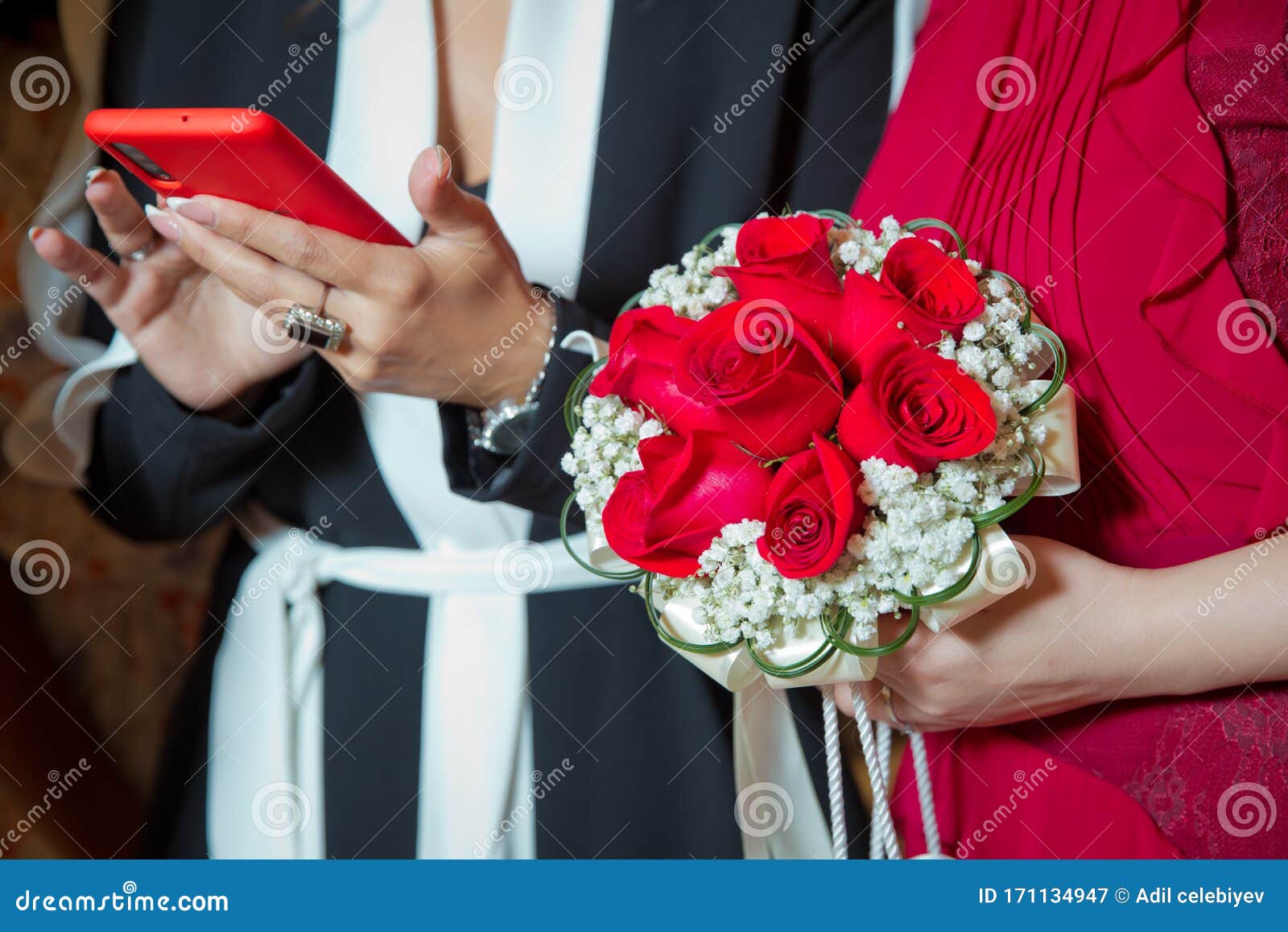 A Garota Tem Um Telefone Vermelho Na Mão Noiva Que Segura O Buquê Vermelho  Do Casamento De Rosas E Flores De Amor a Noiva Tem Um Imagem de Stock -  Imagem de