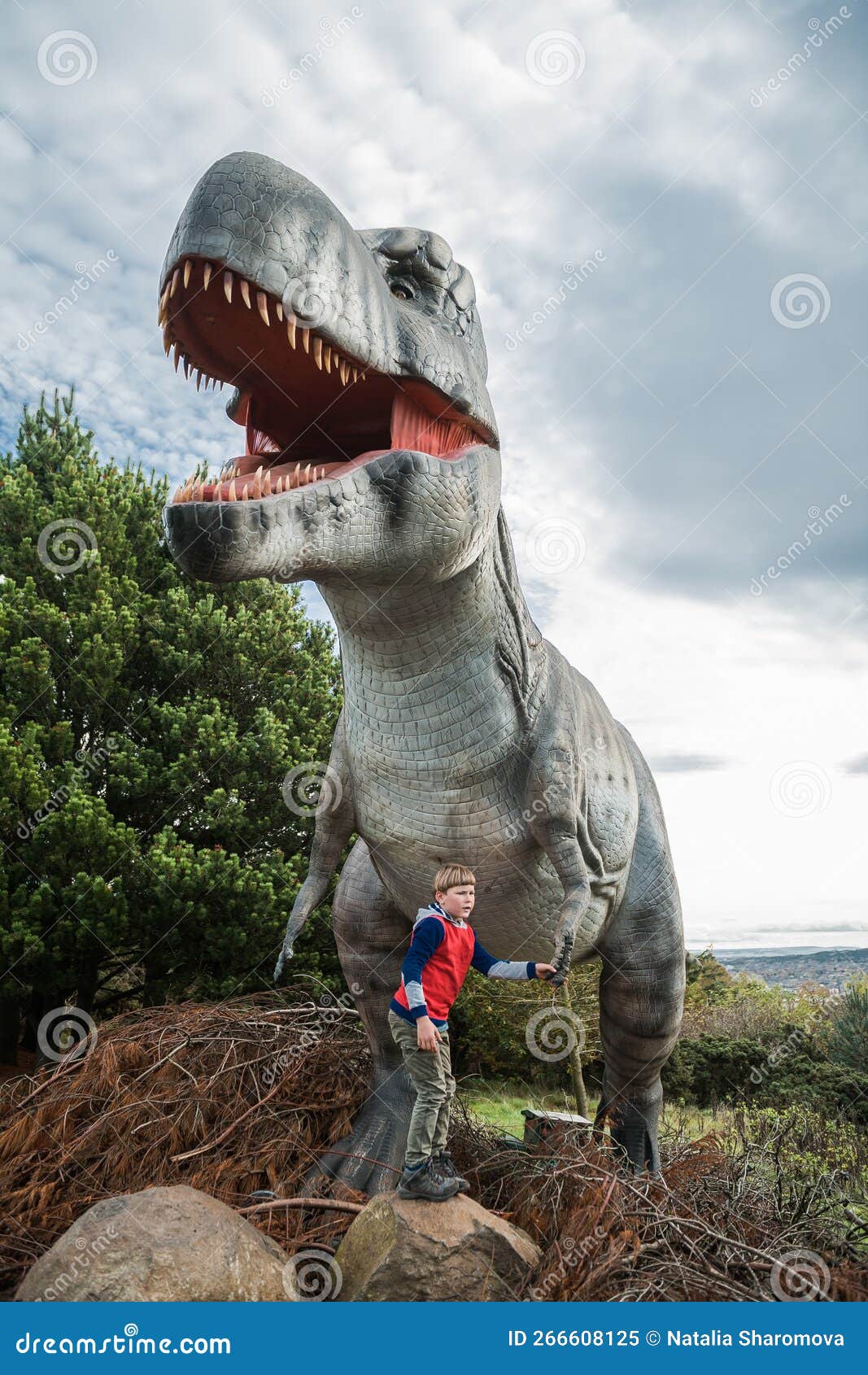 Garotinho Segura a Mão Do Dinossauro Grande. Criança No Enorme