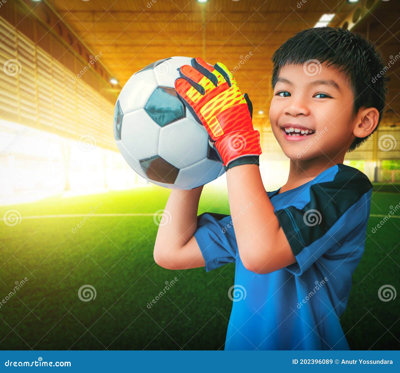 Um garoto segurando a velha bola de futebol antes de começar um jogo de  futebol