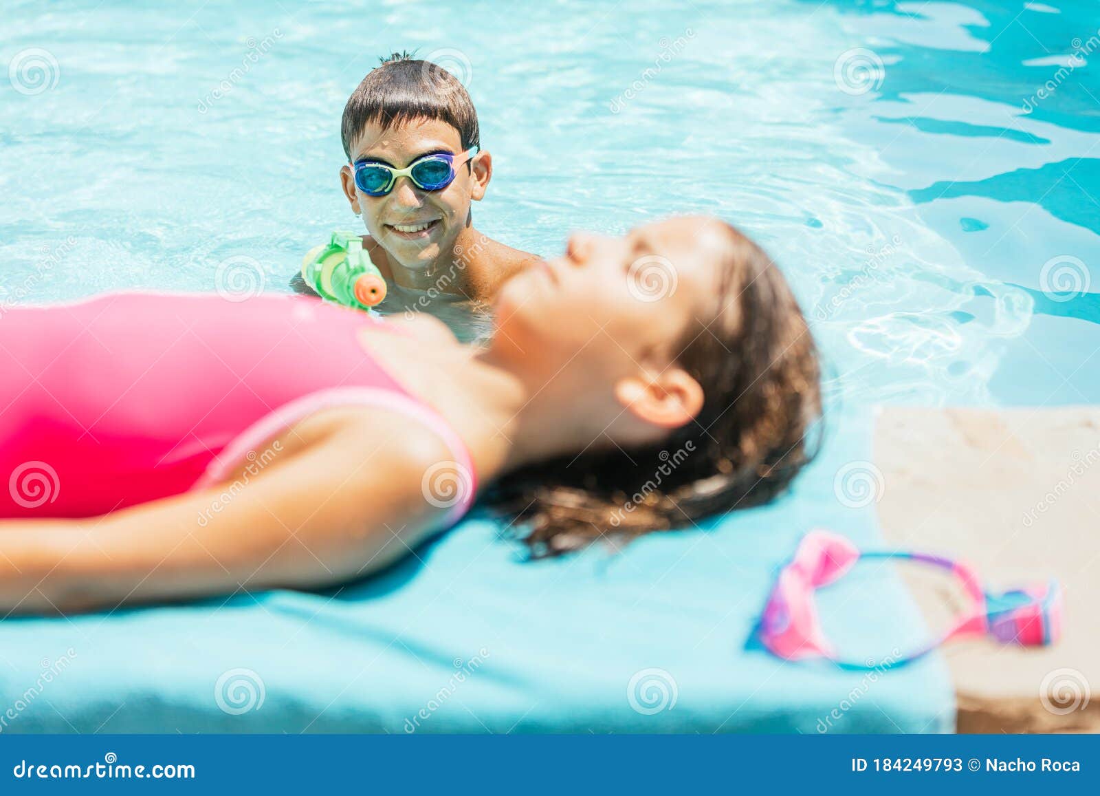 irmão com irmã jogando na piscina de bolinhas coloridas