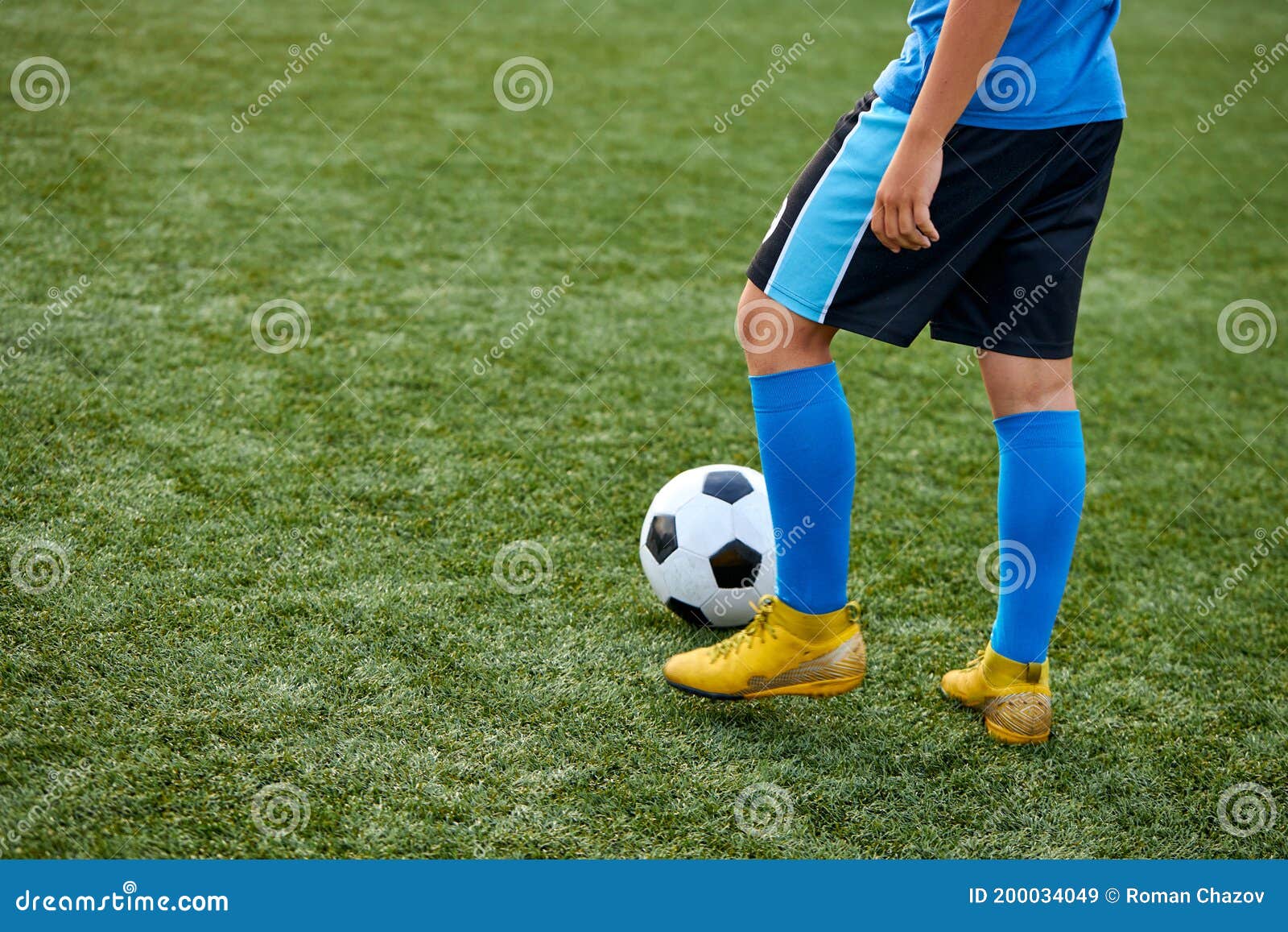 Jogadores de futebol adolescentes chutando bola de futebol campo