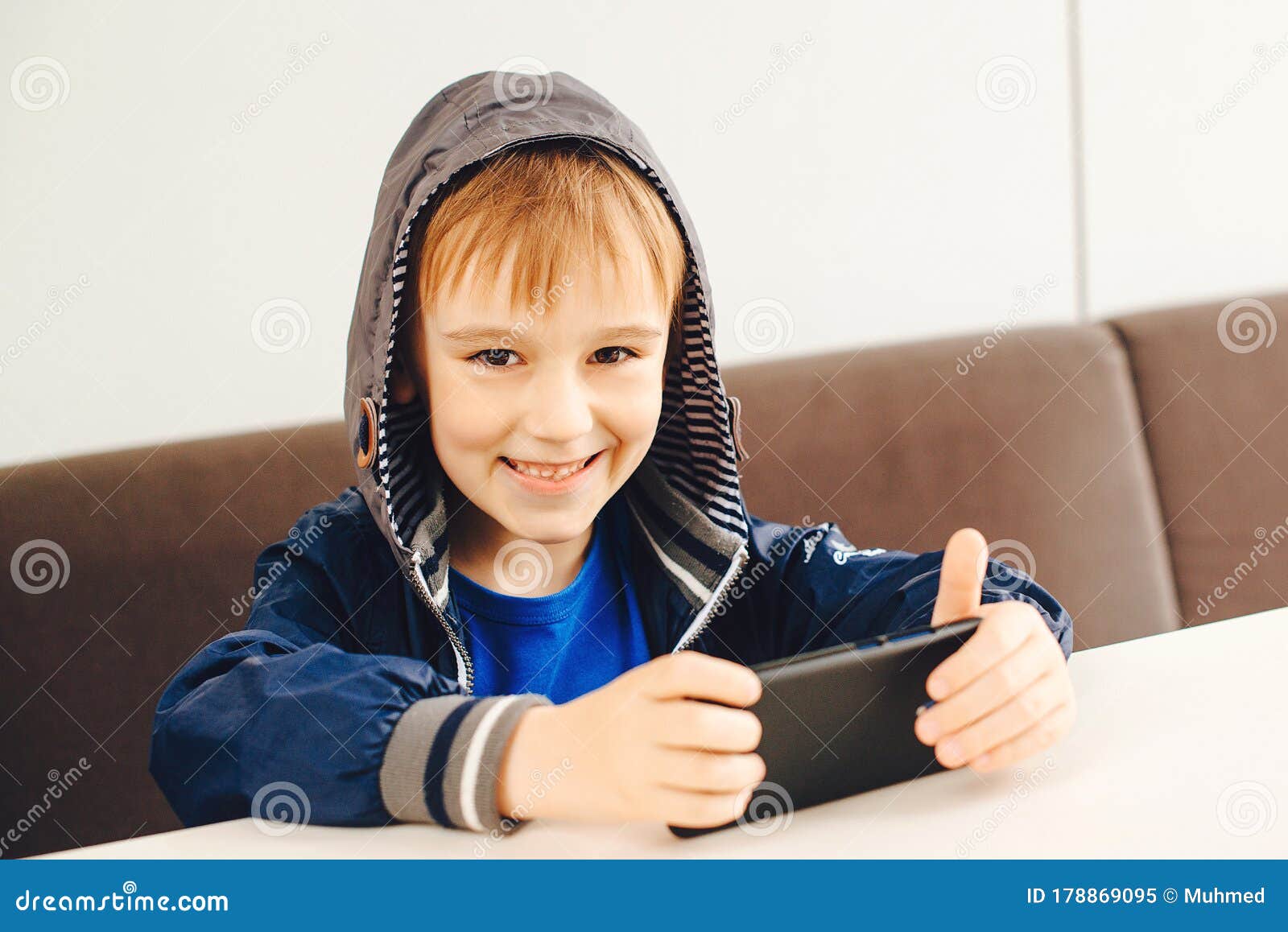 Garoto animado jogando jogo no celular. dois pais ajudando o filho a usar o  aplicativo online no celular. tiro vertical. família em casa e conceito de  comunicação