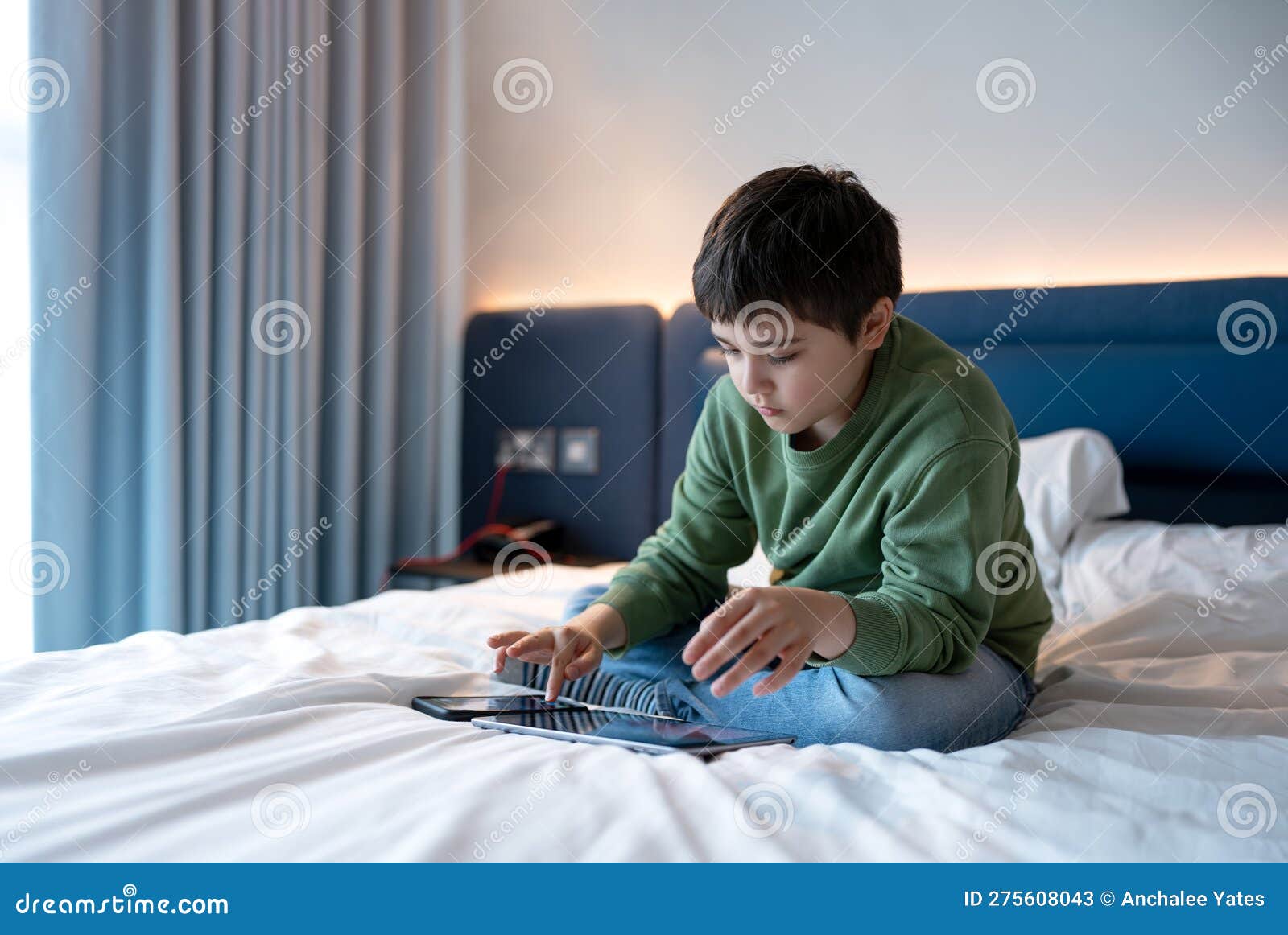 criança jogando jogos online na internet no quarto, retrato de menino  usando tablet digitando ou conversando com amigos de manhã, infância  sentada na cama fazendo lição de casa, criança da escola com