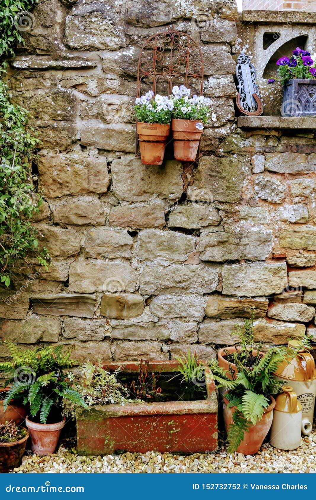 Garten Mit Backsteinmauer- Und Blumenpflanzer Stockfoto - Bild von