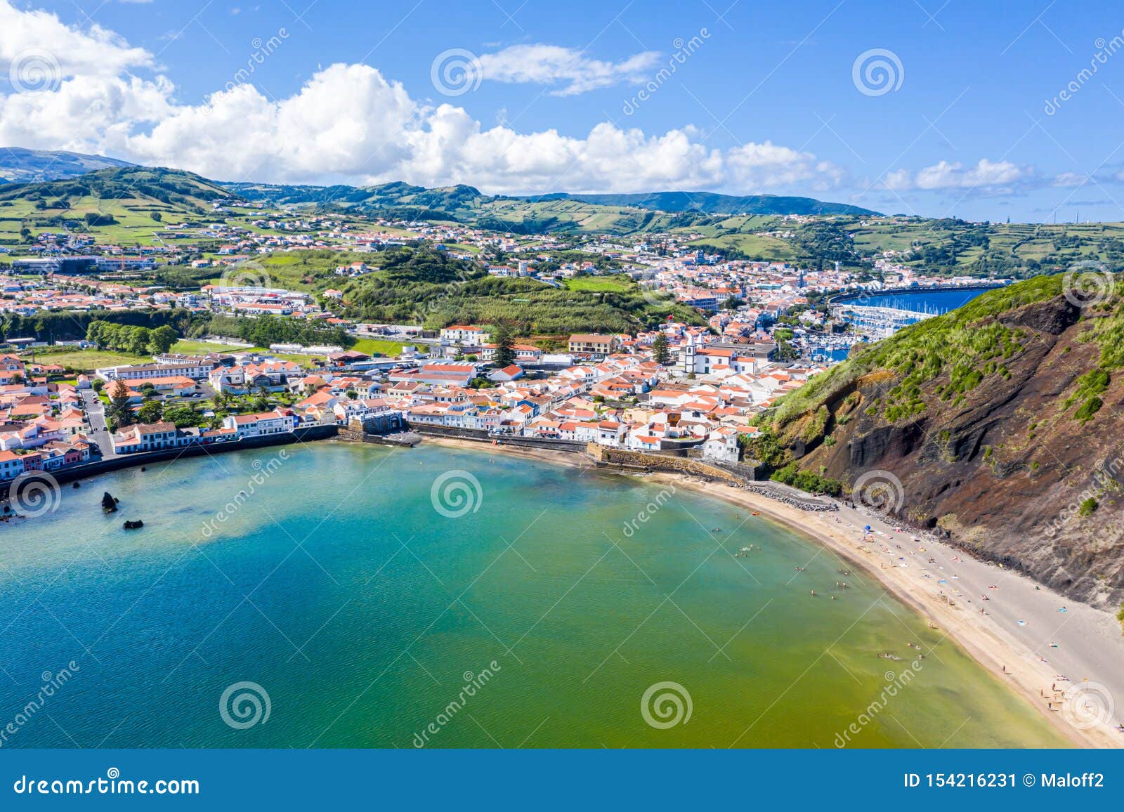 gates portao, idyllic beach praia and azure turquoise baia do porto pim, horta town, faial island, azores, portugal.