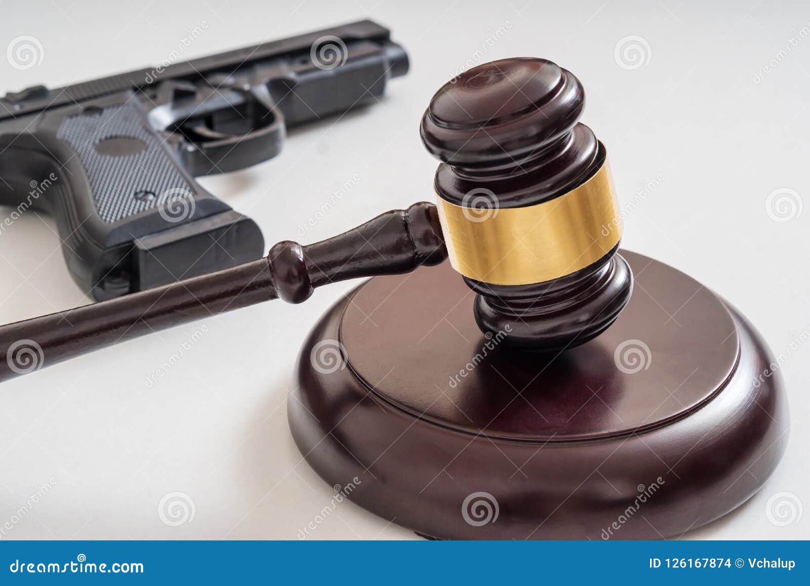 gavel in front of a pistol. gun laws and legislation concept
