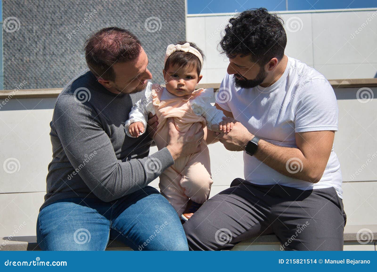 Gay Married Couple Playing Their Daughter Very Happily in the Open Air Stock Photo