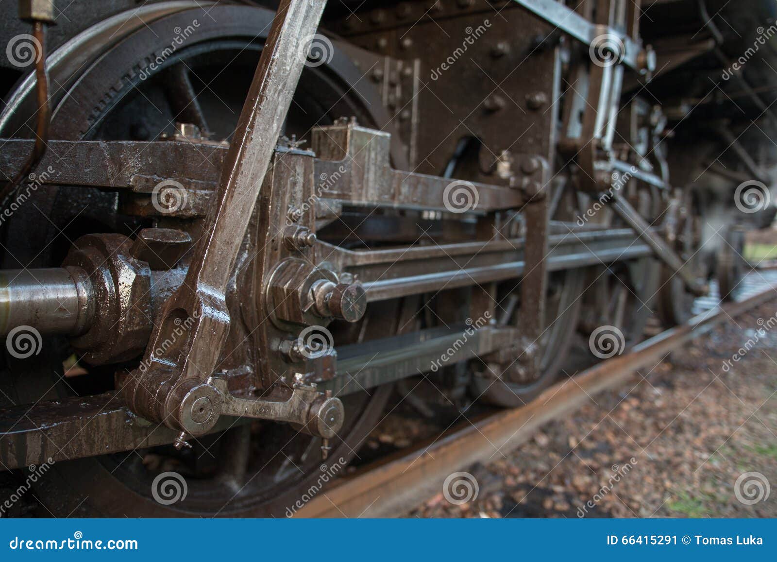 Gearing steam train on tracks. The mechanical part of the steam train on tracks