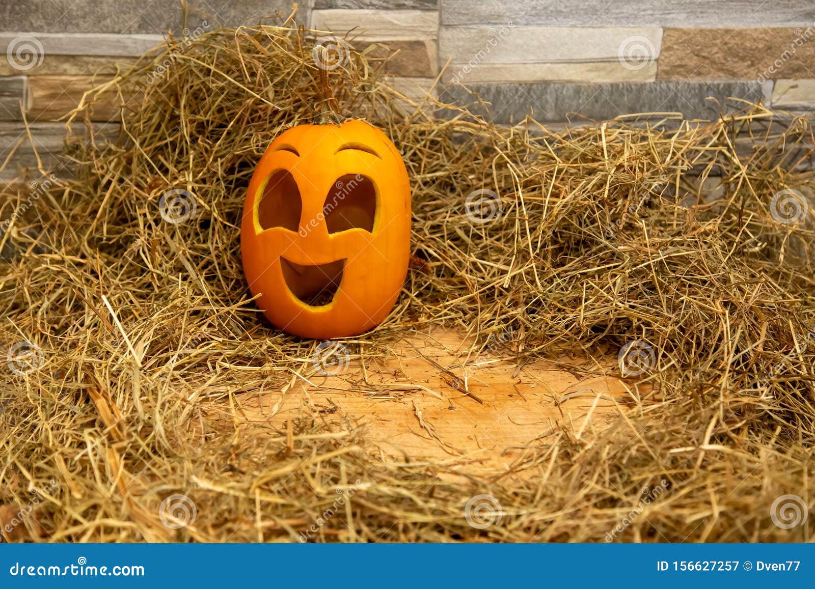 Met Gelukkige Glimlachend Pompoen. Halloween-symbool Stands Op De Stenen Muur Grijs Als Achtergrond Op Hooi En Een Houten Tri Stock Afbeelding - Image of viering, bruin: 156627257