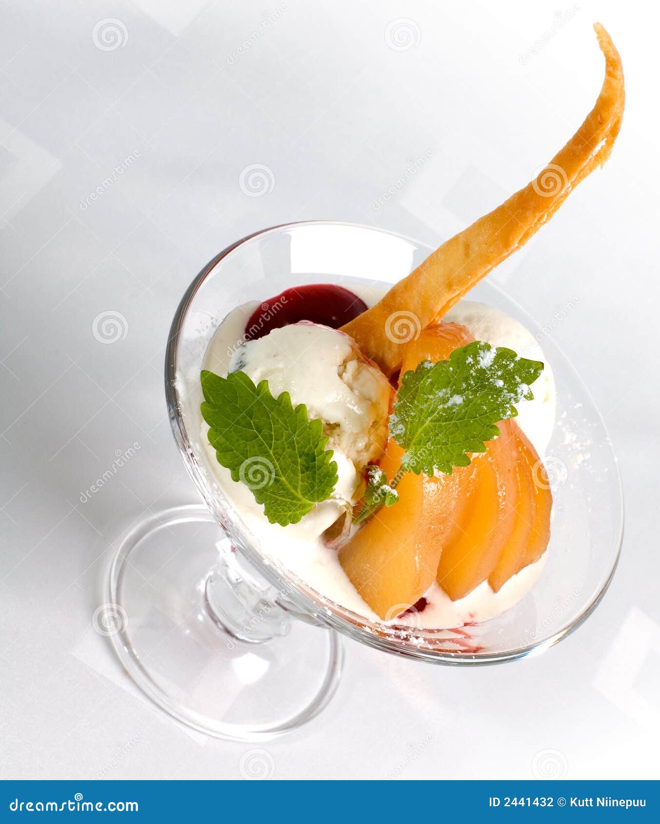 Il gelato con il bastone e la pesca della caramella affetta, in piatto di vetro, il foglio della menta sulla parte superiore