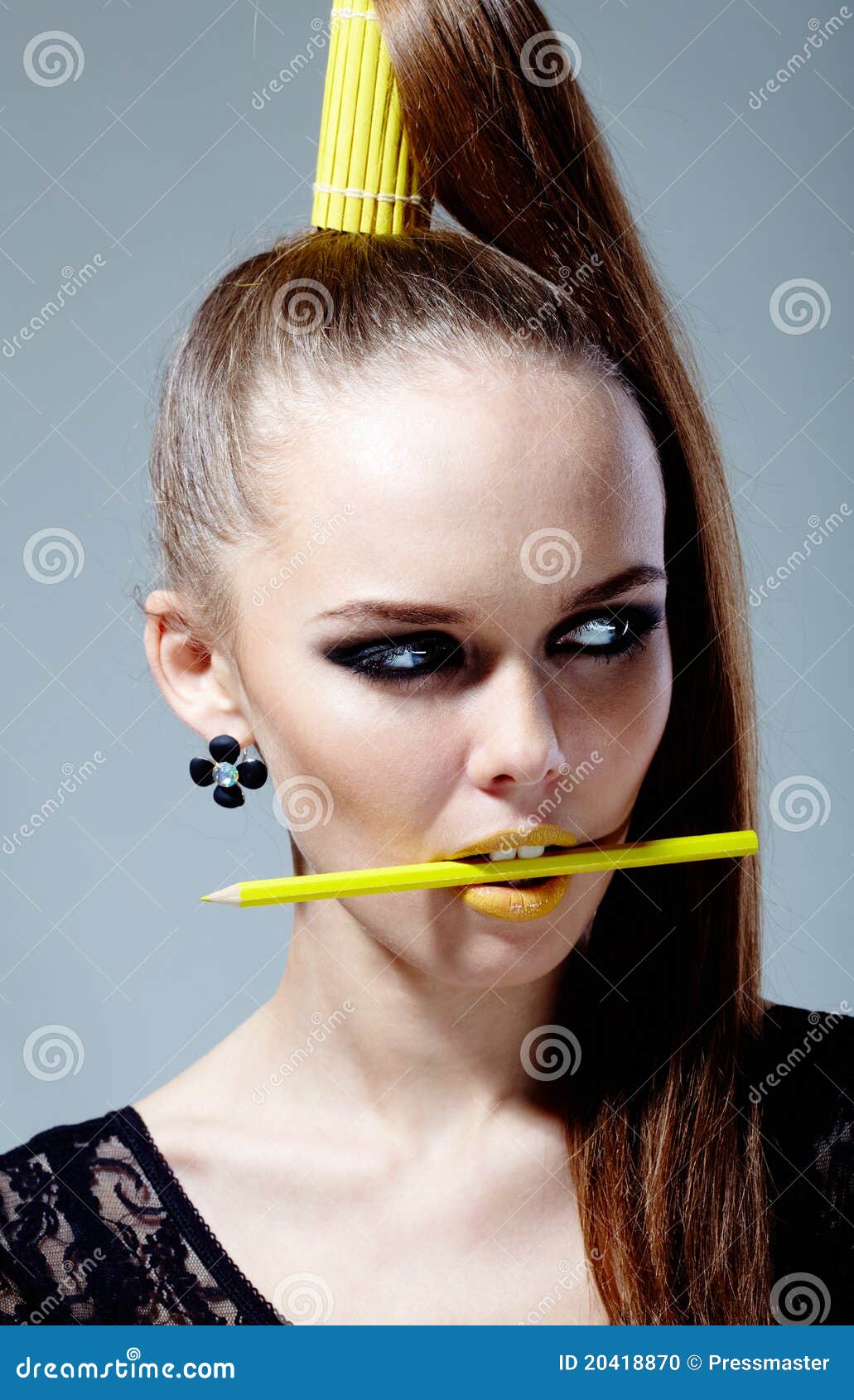 Gele manier. Portret van schitterende vrouw met potlood in mond die opzij eruit ziet
